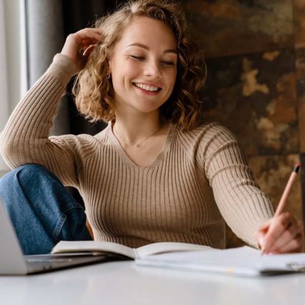 young-white-woman-writing-down-notes-while-working-2023-11-27-05-09-42-utc